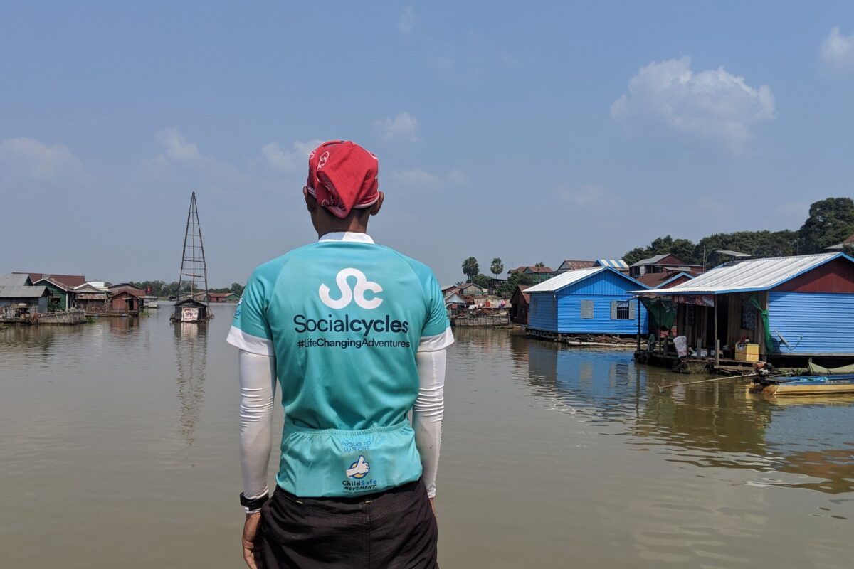 A guide looks out over a floating village from the boat