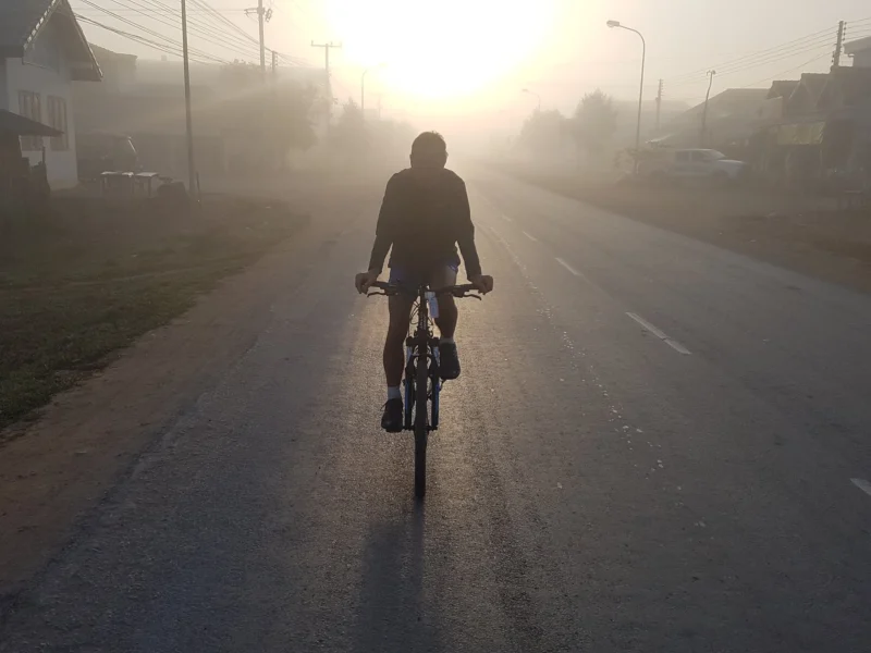 A rider silhouetted in the sunrise fog in Phonsavan
