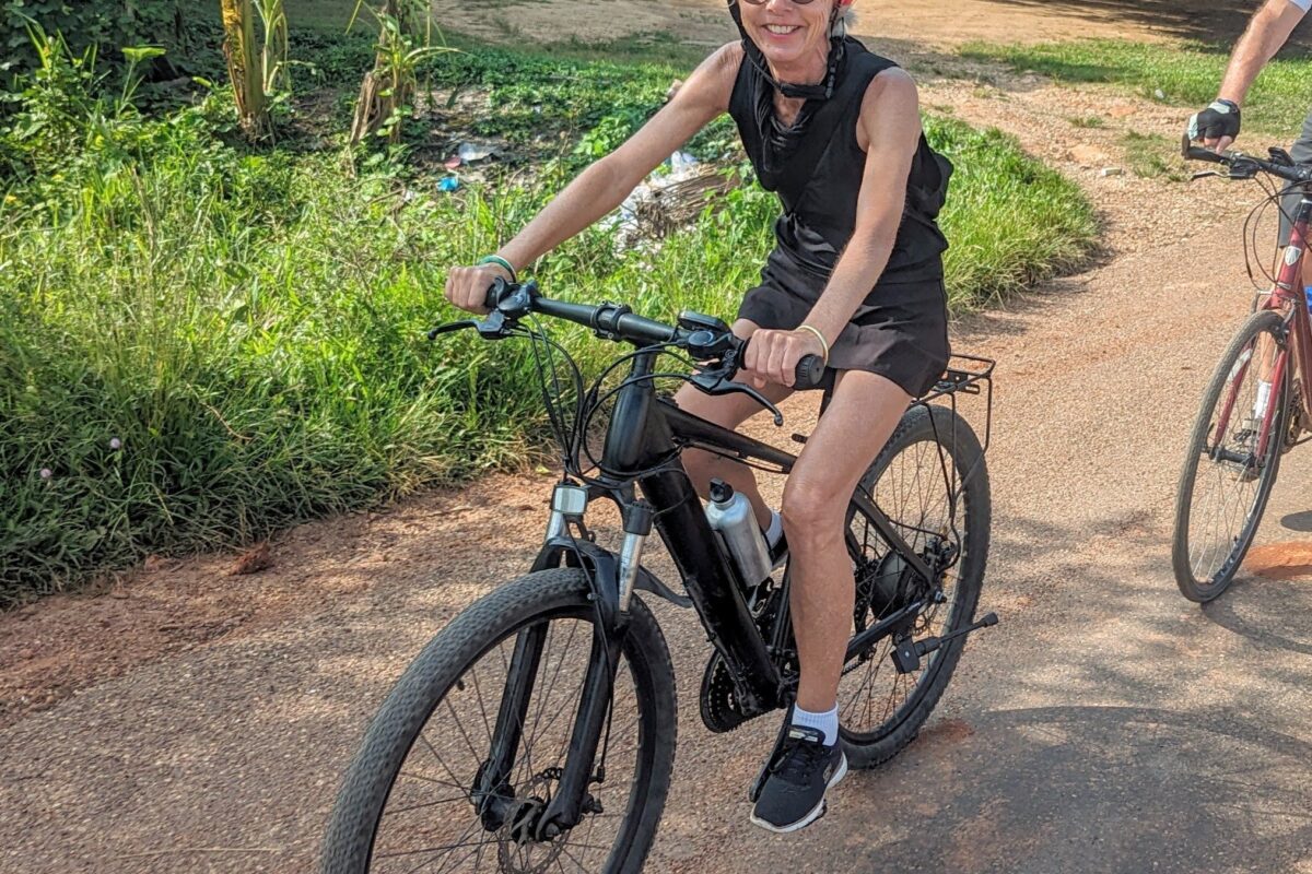 A rider on an e-bike on a red dirt lane