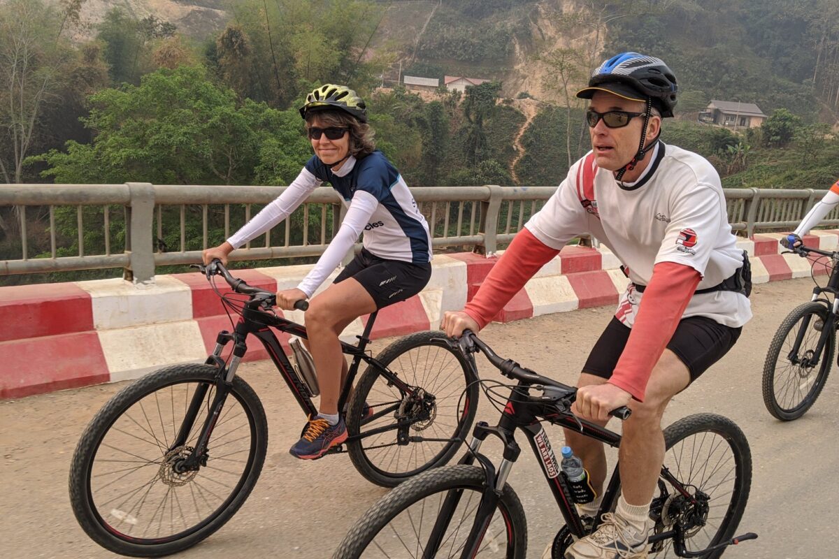 Three riders cross the bridge at Muang Khua