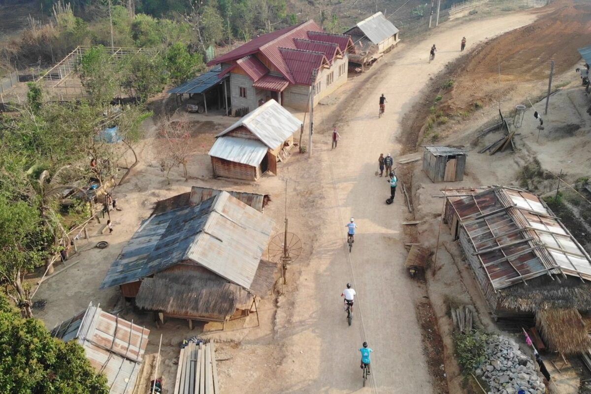 From the air: riders roll through a village of tin roofs