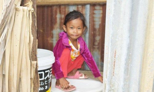 Child sitting in Latrine